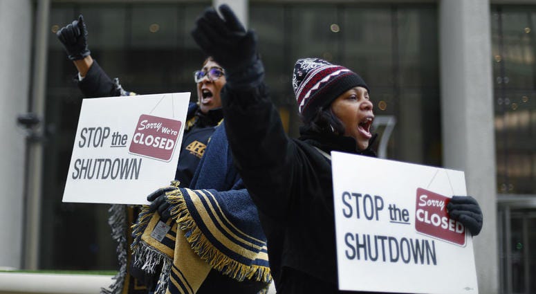 In this Jan. 10, 2019 file photo Cheryl Monroe, right, a Food and Drug Administration employee, and Bertrice Sanders, a Social Security Administration employee, rally to call for an end to the partial government shutdown in Detroit. In this Jan. 10, 2019 file photo Cheryl Monroe, right, a Food and Drug Administration employee, and Bertrice Sanders, a Social Security Administration employee, rally to call for an end to the partial government shutdown in Detroit.
