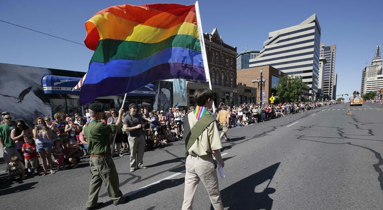In this June 8, 2014, file photo, a group of Boy Scouts march during Salt Lake City's annual gay pride parade. a group of Boy Scouts march during Salt Lake City's annual gay pride parade