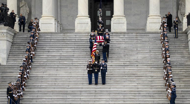A U.S. military honor guard carries the flag-draped casket of the late former President George H.W. Bush down the steps of the U.S. Capitol, December 5, 2018 in Washington, DC. A U.S. military honor guard carries the flag-draped casket of the late former President George H.W. Bush down the steps of the U.S. Capitol, December 5, 2018 in Washington, DC.