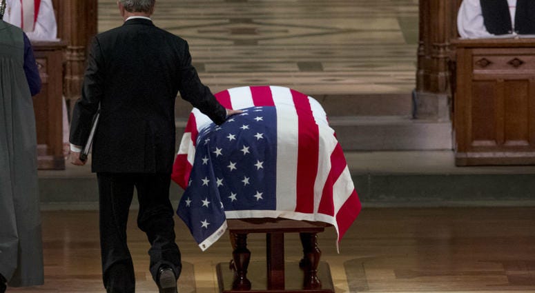 Former President George Bush touches the flag-draped casket of his father, former President George H.W. Bush, as he prepares to speak during his State Funeral at the National Cathedral, December 5, 2018 in Washington, DC. Former President George Bush touches the flag-draped casket of his father, former President George H.W. Bush, as he prepares to speak during his State Funeral at the National Cathedral, December 5, 2018 in Washington, DC.