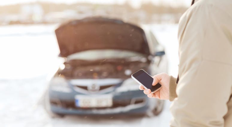 Man makes phone call after car is left stranded in the snow. Stranded Driver