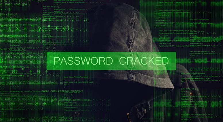 Password Cracked by Faceless hooded anonymous computer hacker with programming code from monitor Computer Hacker