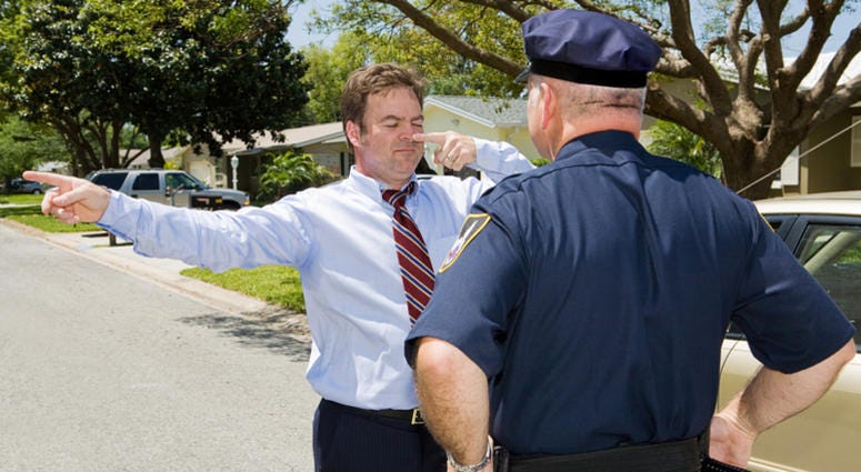 Police officer giving a roadside sobriety test to a drunk driver. drunk driver