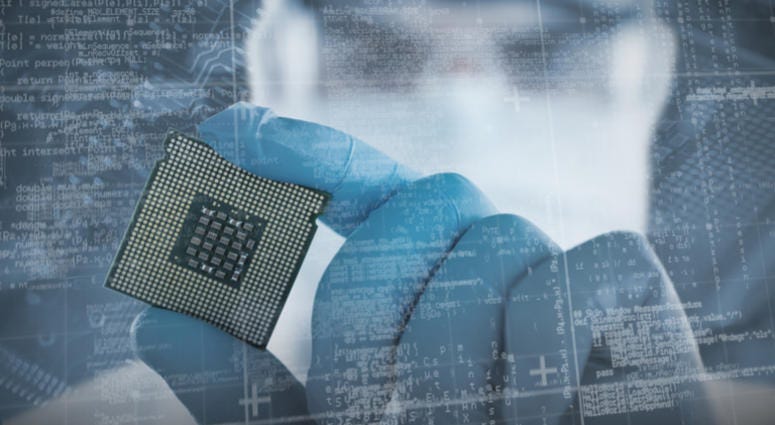 Male doctor in protective glasses and surgical mask holding electronic chip against close-up of circuit board electronic medical device