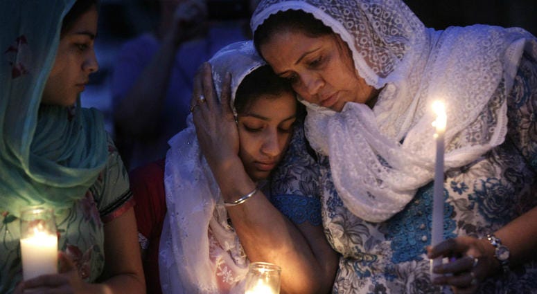 In this Monday, Aug. 6, 2012 file photo, Sikh worshipers gather for a candlelight vigil after prayer services at the Sikh Religious Society of Wisconsin in Brookfield, Wis. In this Monday, Aug. 6, 2012 file photo, Sikh worshipers gather for a candlelight vigil after prayer services at the Sikh Religious Society of Wisconsin in Brookfield, Wis.