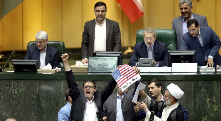 Iranian lawmakers burn two pieces of papers representing the U.S. flag and the nuclear deal as they chant slogans against the U.S. at the parliament in Tehran, Iran, Wednesday, May 9, 2018. Iranian lawmakers burn two pieces of papers representing the U.S. flag and the nuclear deal as they chant slogans against the U.S. at the parliament in Tehran, Iran, Wednesday, May 9, 2018.