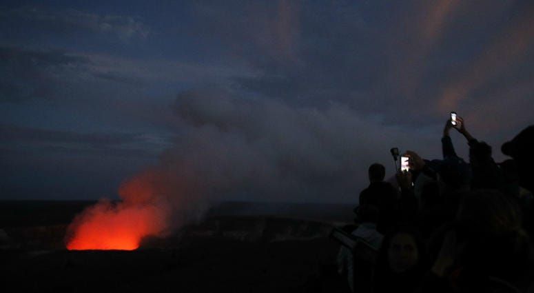 Visitors take pictures as Kilauea's summit crater glows red in Volcanoes National Park, Hawaii, Wednesday, May 9, 2018. Visitors take pictures as Kilauea's summit crater glows red in Volcanoes National Park, Hawaii, Wednesday, May 9, 2018.