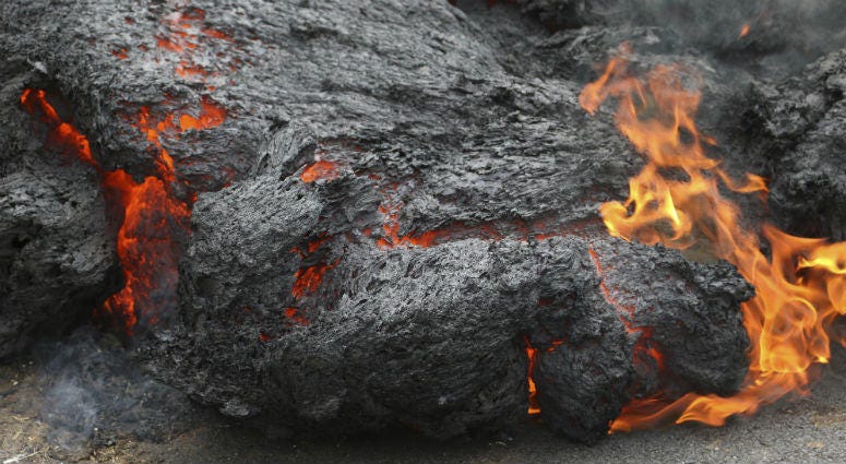In this May 5, 2018, file photo, lava burns across a road in the Leilani Estates subdivision near Pahoa, Hawaii. In this May 5, 2018, file photo, lava burns across a road in the Leilani Estates subdivision near Pahoa, Hawaii.