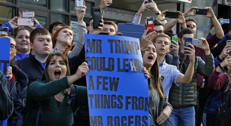 University of Pittsburgh sophomore Lynne Jaworski, from Homer City, Pa., holds a sign and yells as President Donald Trump's motorcade arrives at the University of Pittsburgh's Presbyterian Hospital. University of Pittsburgh sophomore Lynne Jaworski, from Homer City, Pa., holds a sign and yells as President Donald Trump's motorcade arrives at the University of Pittsburgh's Presbyterian Hospital.