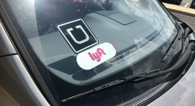 Lyft and Uber stickers on a car.