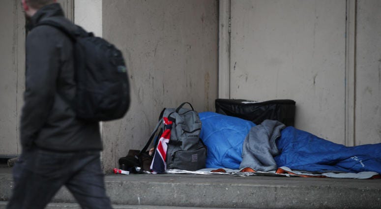 A homeless person sleeping in a doorway. A homeless person sleeping in a doorway.