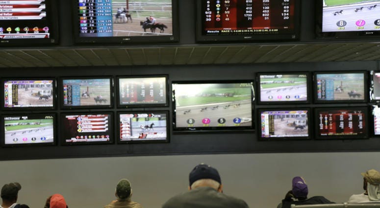 In this May 14, 2018, file photo, men watch horse racing on an array of screens at Monmouth Park Racetrack in Oceanport, N.J. In this May 14, 2018, file photo, men watch horse racing on an array of screens at Monmouth Park Racetrack in Oceanport, N.J.