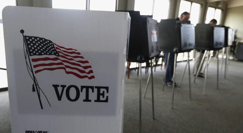 In this March 18, 2014 file photo, voters cast their ballots in Hinsdale, Ill. In this March 18, 2014 file photo, voters cast their ballots in Hinsdale, Ill.