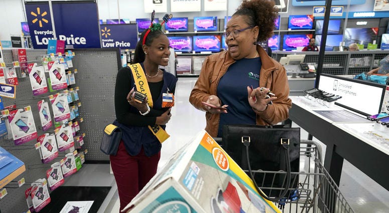 Walmart associate Shanay Bishop, left, checks out customer Carolyn Sarpy on the sales floor as part of the "Check Out With Me" program at a Walmart Supercenter in Houston. Walmart associate Shanay Bishop, left, checks out customer Carolyn Sarpy on the sales floor as part of the "Check Out With Me" program at a Walmart Supercenter in Houston.