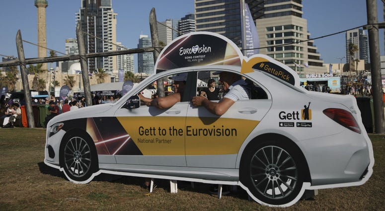 People pose in a cutout taxi cab ahead of the 2019 Eurovision Song Contest in Tel Aviv, Israel, Monday, May 13, 2019. People pose in a cutout taxi cab ahead of the 2019 Eurovision Song Contest in Tel Aviv, Israel, Monday, May 13, 2019.