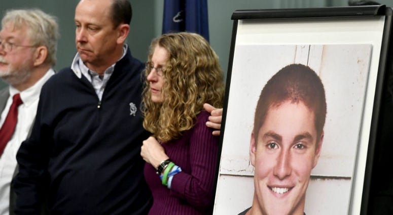 In this May 5, 2017, file photo, Jim and Evelyn Piazza, center, stand by as Centre County, Pa., prosecutors discuss an investigation into the death of their son Timothy Piazza, seen in photo at right, during a news conference in Bellefonte, Pa. Jim and Evelyn Piazza