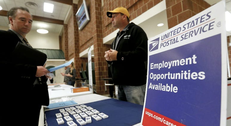 In this Nov. 2, 2017, file photo a recruiter from the postal service, right, speaks with an attendee of a job fair in the cafeteria of Deer Lakes High School in Cheswick, Pa. In this Nov. 2, 2017, file photo a recruiter from the postal service, right, speaks with an attendee of a job fair in the cafeteria of Deer Lakes High School in Cheswick, Pa.