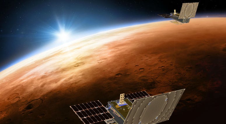 Twin Mars Cube One project (MarCO) spacecrafts flying over Mars with Earth and the sun in the distance. Twin Mars Cube One project (MarCO) spacecrafts flying over Mars with Earth and the sun in the distance.