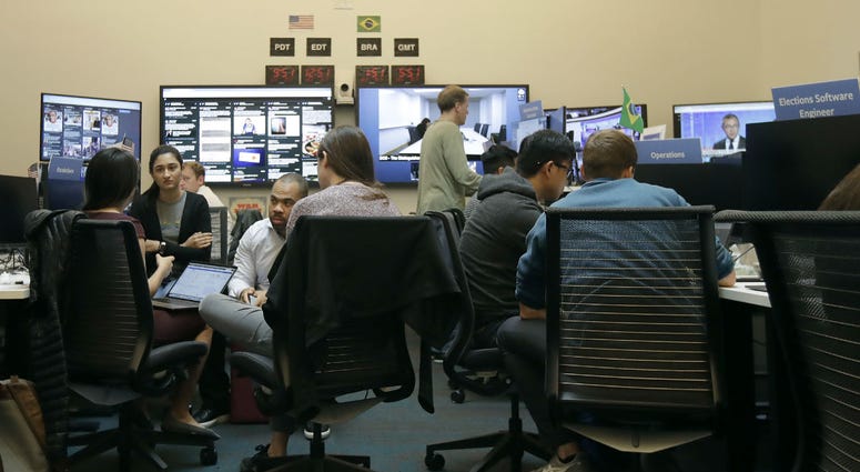 Workers gather and sit and their desks during a demonstration in the war room, where Facebook monitors election related content on the platform, in Menlo Park, Calif., Wednesday, Oct. 17, 2018. Workers gather and sit and their desks during a demonstration in the war room, where Facebook monitors election related content on the platform, in Menlo Park, Calif., Wednesday, Oct. 17, 2018.