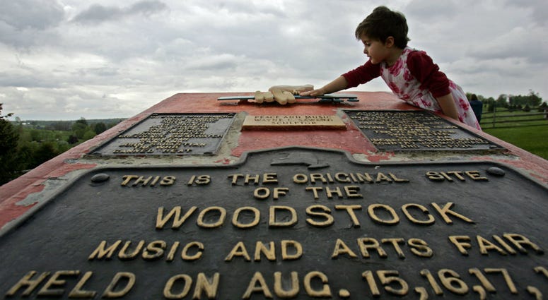 This May 15, 2008 file photo shows Emma Cenholt, 3, of Trumbull, Conn., playing on a memorial at the site of the Woodstock Music and Arts Fair in Bethel, N.Y. This May 15, 2008 file photo shows Emma Cenholt, 3, of Trumbull, Conn., playing on a memorial at the site of the Woodstock Music and Arts Fair in Bethel, N.Y.