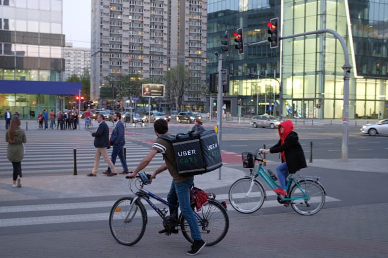 An Uber Eats meal delivery bicyclist arrives at an intersection in the city center on April 18, 2018 in Warsaw, Poland. Uber Eats is the biggest meal delivery service in the USA and is expanding aggressively internationally. (Photo by Sean Gallup/Getty I