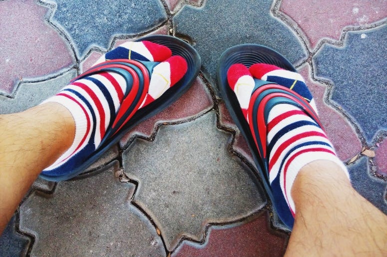 Adrian Teoh / Getty Images Man in Socks & Flip Flops