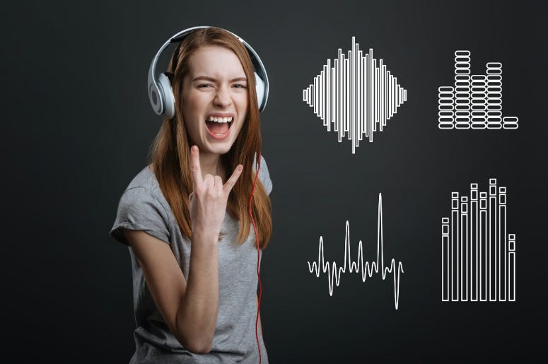 Excited teenager showing a rock sign while listening to music in headphones Excited teenager showing a rock sign while listening to music in headphones