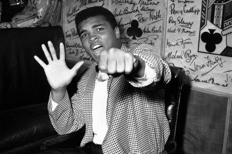 Cassius Clay a.k.a. Muhammad Ali 27th May 1963: Supremely confident American boxer Cassius Clay holds up five fingers in a prediction of how many rounds it will take him to knock out British boxer Henry Cooper. (Photo by Kent Gavin/Keystone/Getty Images)