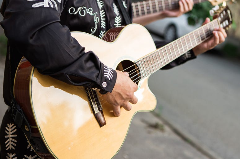 Musician playing guitar Man plays the guitar, close-up of hands. Latin American, Spanish, Mexican musician (Photo credit: Getty Images Plus )