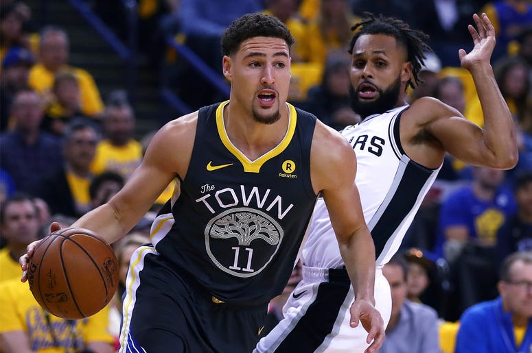 AP18107124163341 Golden State Warriors' Klay Thompson (11) drives the ball away from San Antonio Spurs' Patty Mills, right, during the first quarter in Game 2 of a first-round NBA basketball playoff series Monday, April 16, 2018, in Oakland, Calif. (AP Photo/Ben Margot)