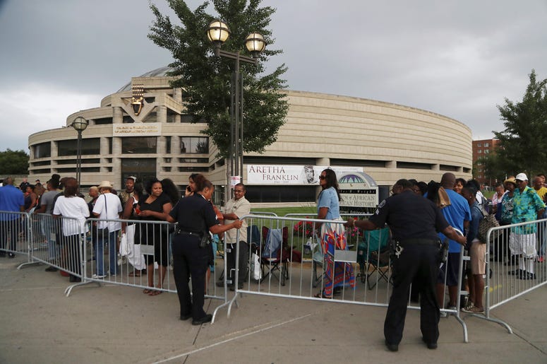AP18240486272085 Detroit police help with a barricade at the Charles H. Wright Museum of African American History where fans line up to pay their final respects to Aretha Franklin, Tuesday, Aug. 28, 2018, in Detroit. (AP Photo/Carlos Osorio)
