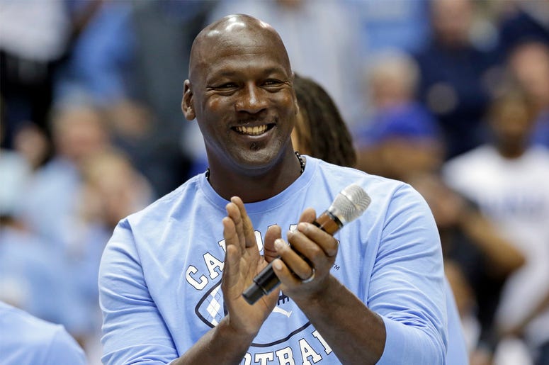 AP18261701684313 In this March 4, 2017, file photo, former North Carolina basketball player Michael Jordan applauds during a half-time presentation at an NCAA college basketball game between North Carolina and Duke in Chapel Hill, N.C. Jordan, who played high school baske