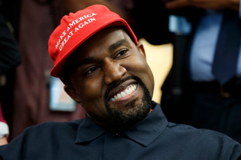 AP18284625766631 Rapper Kanye West smiles as he listens to a question from a reporter during a meeting in the Oval Office of the White House with President Donald Trump, Thursday, Oct. 11, 2018, in Washington. (AP Photo/Evan Vucci)