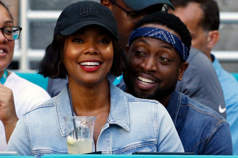 AP18312804538539 In this Sunday, Oct. 14, 2018 file photo, Miami Heat player Dwyane Wade and his wife Gabrielle Union-Wade acknowledge the cheers from the crowd during the second half of an NFL football game between the Miami Dolphins and the Chicago Bears in Miami Garden