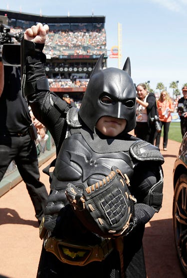 AP18319827192932 In this file photo from Tuesday, April 8, 2014, Miles Scott, dressed as Batkid, gestures after throwing the ceremonial first pitch before a baseball game between the San Francisco Giants and the Arizona Diamondbacks in San Francisco. On the five-year anni