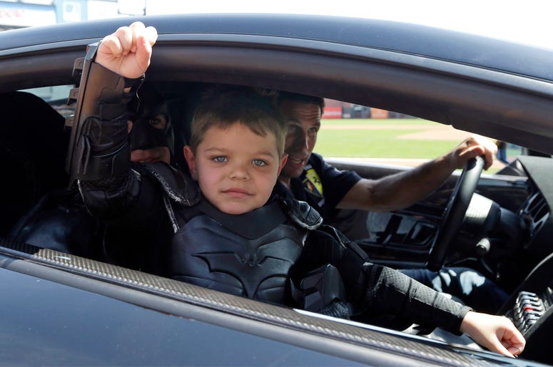 AP18319828923244 In this file photo from Tuesday, April 8, 2014, Miles Scott, dressed as Batkid, gestures as he sits in the Batmobile after throwing the ceremonial first pitch before a baseball game between the San Francisco Giants and the Arizona Diamondbacks in San Fran