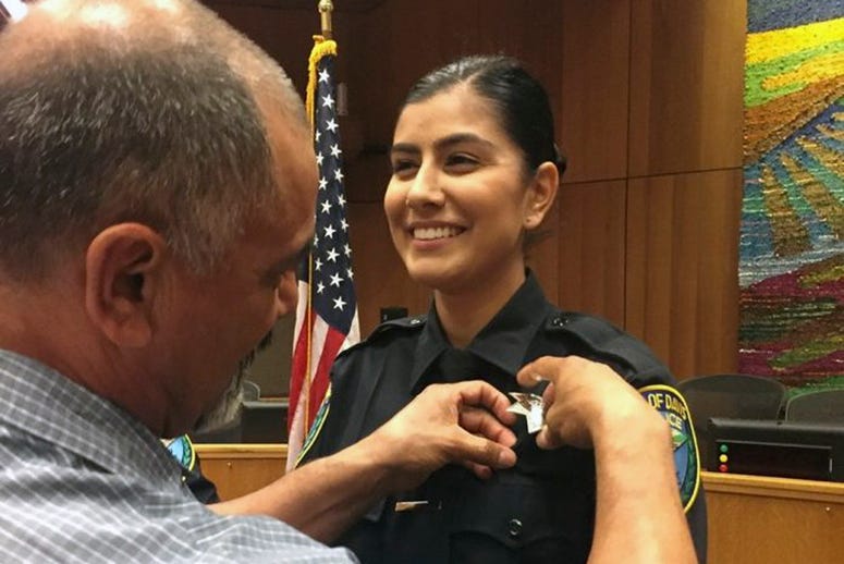 AP19011632271458 This Aug. 2, 2018 photo provided by Williams Pioneer Review shows Merced Corona, left, pins his daughter Natalie Corona's badge on her uniform during a swearing-in ceremony in Davis, Calif. Natalie Corona was shot and killed during a routine call Thursday