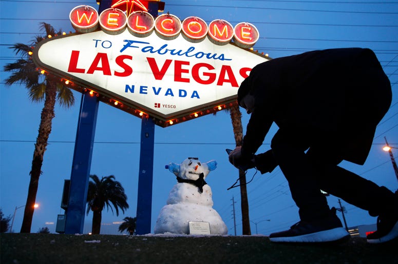 AP19052566507904 A man, who declined to give his name, takes a picture of a small snowman at the "Welcome to Fabulous Las Vegas" sign along the Las Vegas Strip, Thursday, Feb. 21, 2019, in Las Vegas. (AP Photo/John Locher)