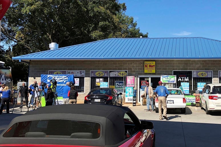 AP19063797336963 In this Oct. 24, 2018, file photo, media, at left, record people entering the KC Mart in Simpsonville, S.C., after it was announced the winning Mega Millions lottery ticket was purchased at the store. (AP Photo/Jeffrey Collins, File)
