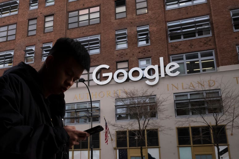 AP19078598755108 In this Dec. 17, 2018, file photo a man using a mobile phone walks past Google offices in New York. (AP Photo/Mark Lennihan, File)