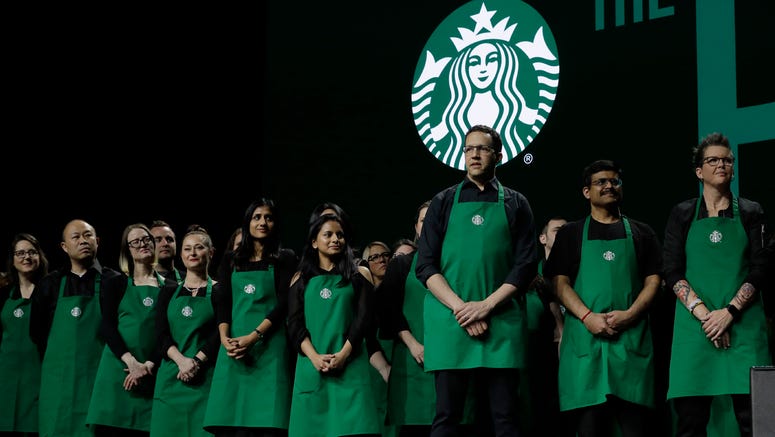 AP19079714317179 Starbucks baristas stand on stage, Wednesday, March 20, 2019, during Starbuck's annual shareholders meeting in Seattle. (AP Photo/Ted S. Warren)