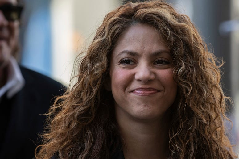 AP19086356853819 Colombian singers Shakira, right, and Carlos Vives, background, arrive at court in Madrid, Spain, Wednesday, March 27, 2019. (AP Photo)
