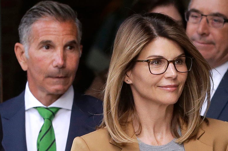 AP19099640965711 In this April 3, 2019 file photo, actress Lori Loughlin, front, and husband, clothing designer Mossimo Giannulli, left, depart federal court in Boston after facing charges in a nationwide college admissions bribery scandal. (AP Photo/Steven Senne, File)