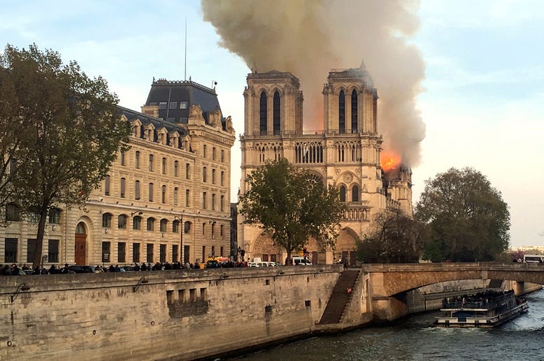 AP19105641561879 Flames rise from Notre Dame cathedral as it burns in Paris, Monday, April 15, 2019. (AP Photo/Lori Hinant)