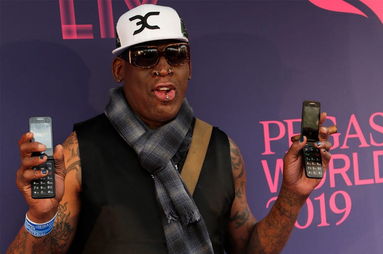 AP19132007715548 In this Jan. 26, 2019, file photo, Dennis Rodman poses with two flip phones on the blue carpet at the Pegasus World Cup Invitational Horse Race at Gulfstream Park in Hallandale Beach, Fla. (AP Photo/Lynne Sladky, File)
