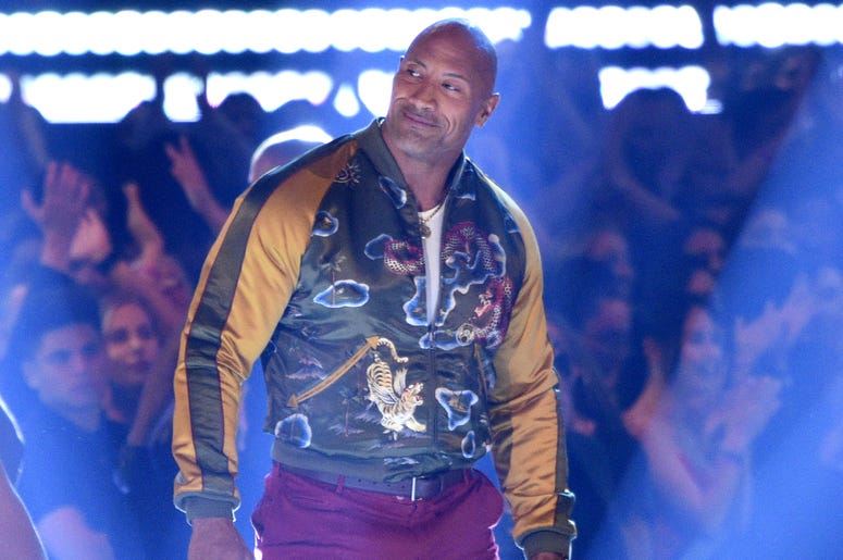 AP19169045853632 Dwayne Johnson, also known as The Rock, center, accepts the generation award at the MTV Movie and TV Awards on Saturday, June 15, 2019, at the Barker Hangar in Santa Monica, Calif. (Photo by Chris Pizzello/Invision/AP)
