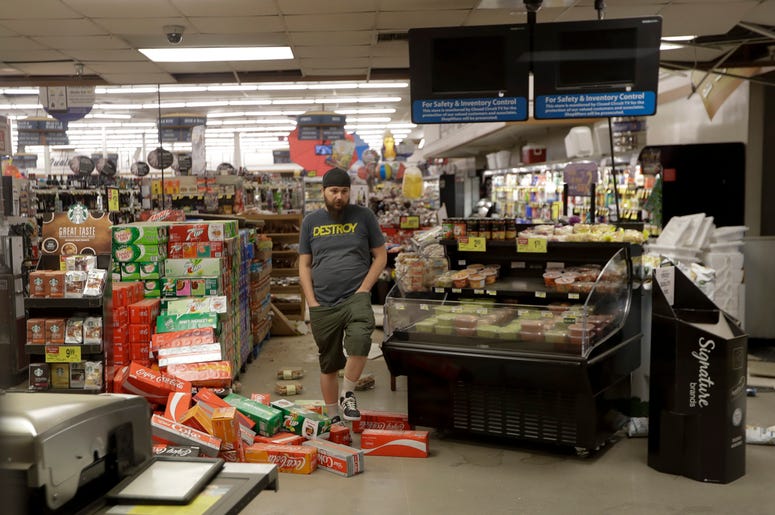 AP19187346904662 A worker steps over merchandise that is scattered on the floor of a Albertson's grocery store Saturday, July 6, 2019 following a earthquake in Ridgecrest, California. (AP Photo/Marcio Jose Sanchez)