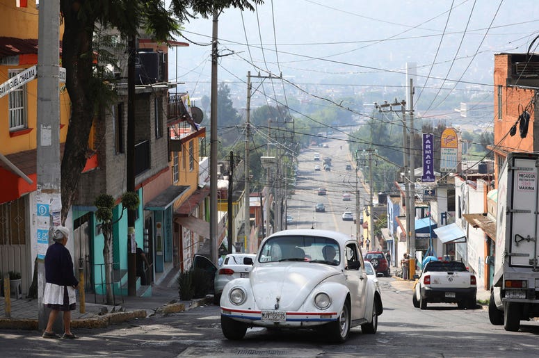 AP19191733162363 A Volkswagen Beetle makes it to the top of a hill in a neighborhood of Mexico City known colloquially as "Vocholandia," for its love of the classic Beetle, called vochos, Tuesday, July 9, 2019. (AP Photo/Cristina Baussan)