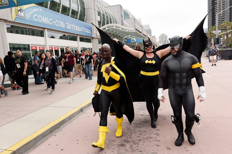 AP19199104372480 Jay Acey of New York City, left, dressed as DC Comics character "Black Adam," Faeren Adams of San Diego, center, dressed as "Batgirl," and Derek Shackleton of San Diego, dressed as DC Comics character "Wildcat," walk together outside Preview Night at the