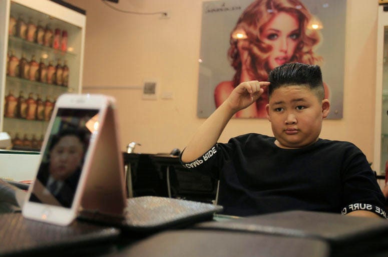 To Gia Huy, 9, checks his hair after having a Kim Jong Un haircut in Hanoi, Vietnam, on Tuesday, Feb. 19, 2019. U.S. President Donald Trump and North Korean leader Kim Jong Un have become the latest style icons in Hanoi, a week before their second summit